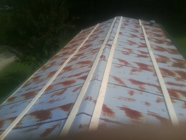 Rusted metal roof panels with new wood purlins before replacement — Storm Damage Roof Repair in Jacksonville Beach by Roofing Brothers