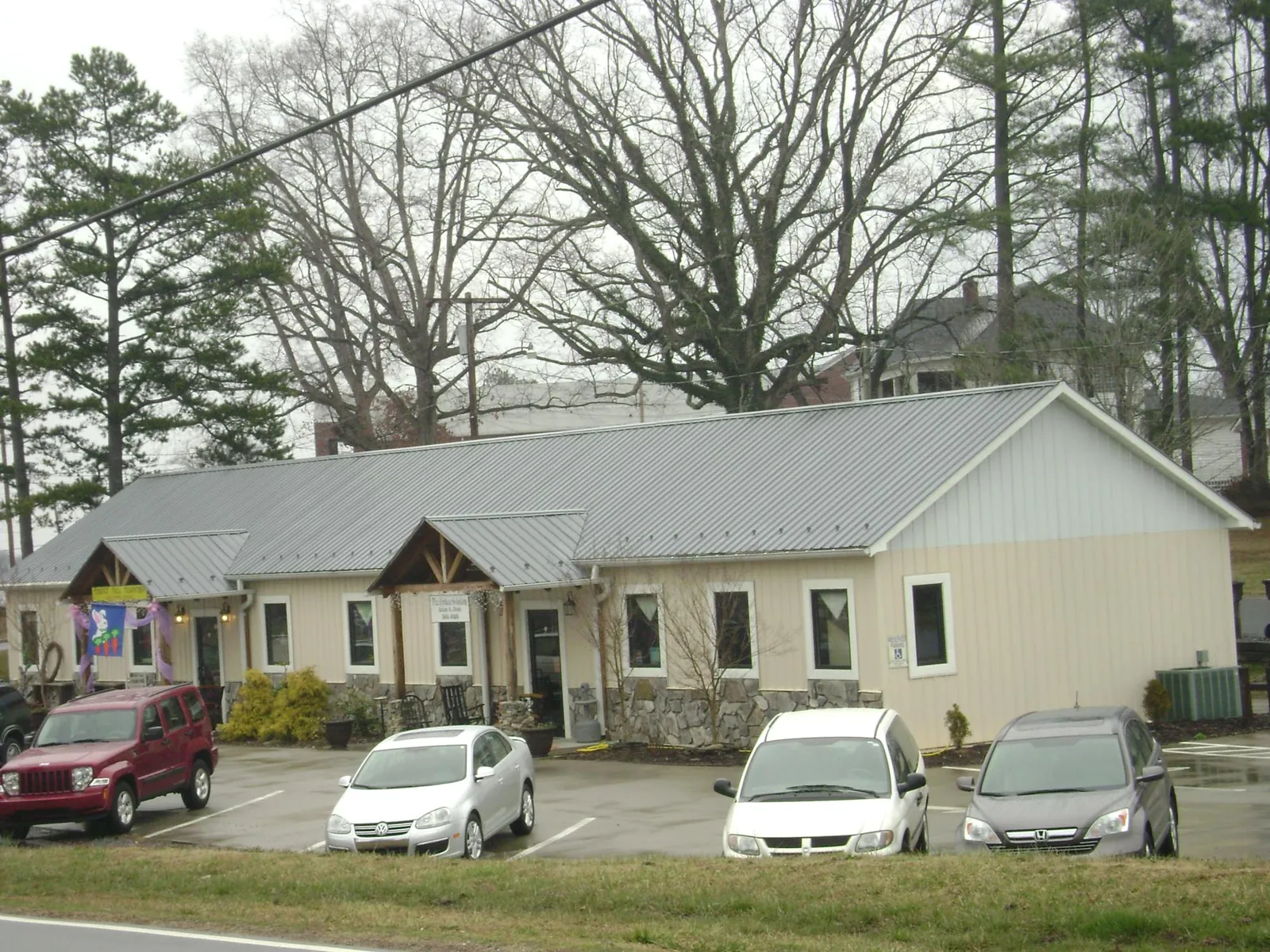 Gray metal roof with timber entry brackets on a small commercial building in Jacksonville Beach
