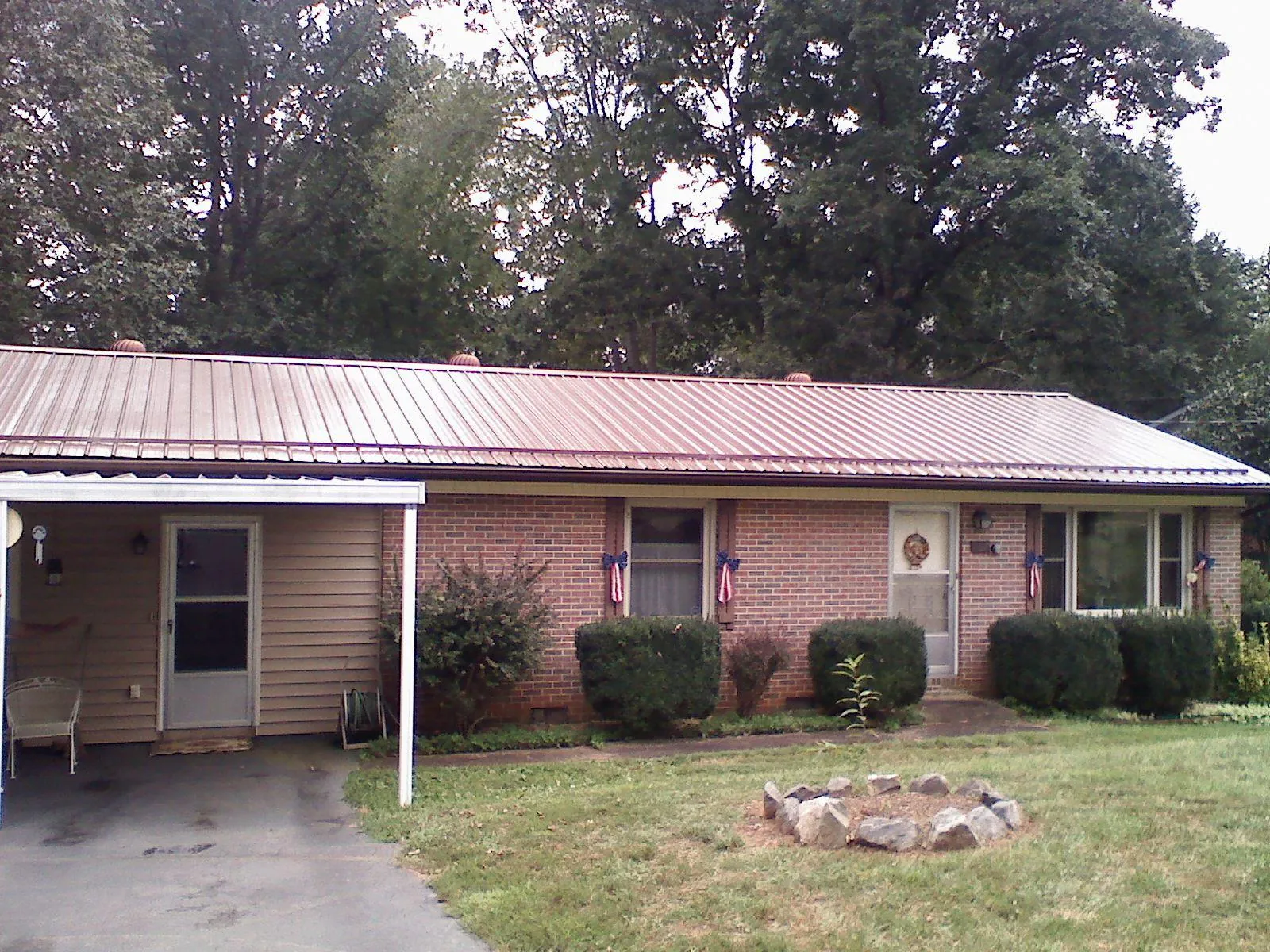 Bronze metal roof and carport on a brick ranch home — Roof Repair work by our crew in Jacksonville Beach